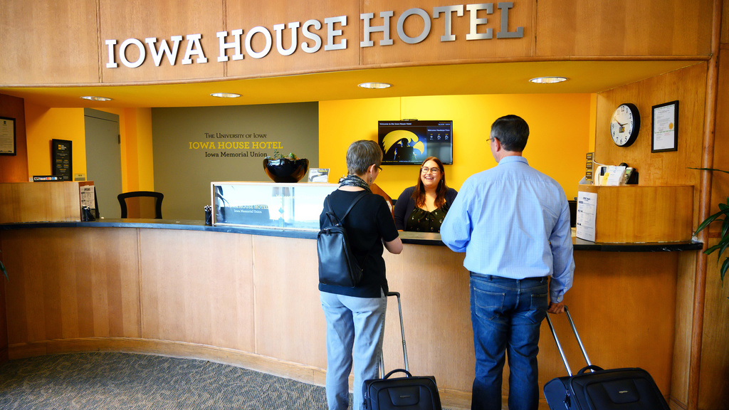 two people standing at iowa house hotel front desk